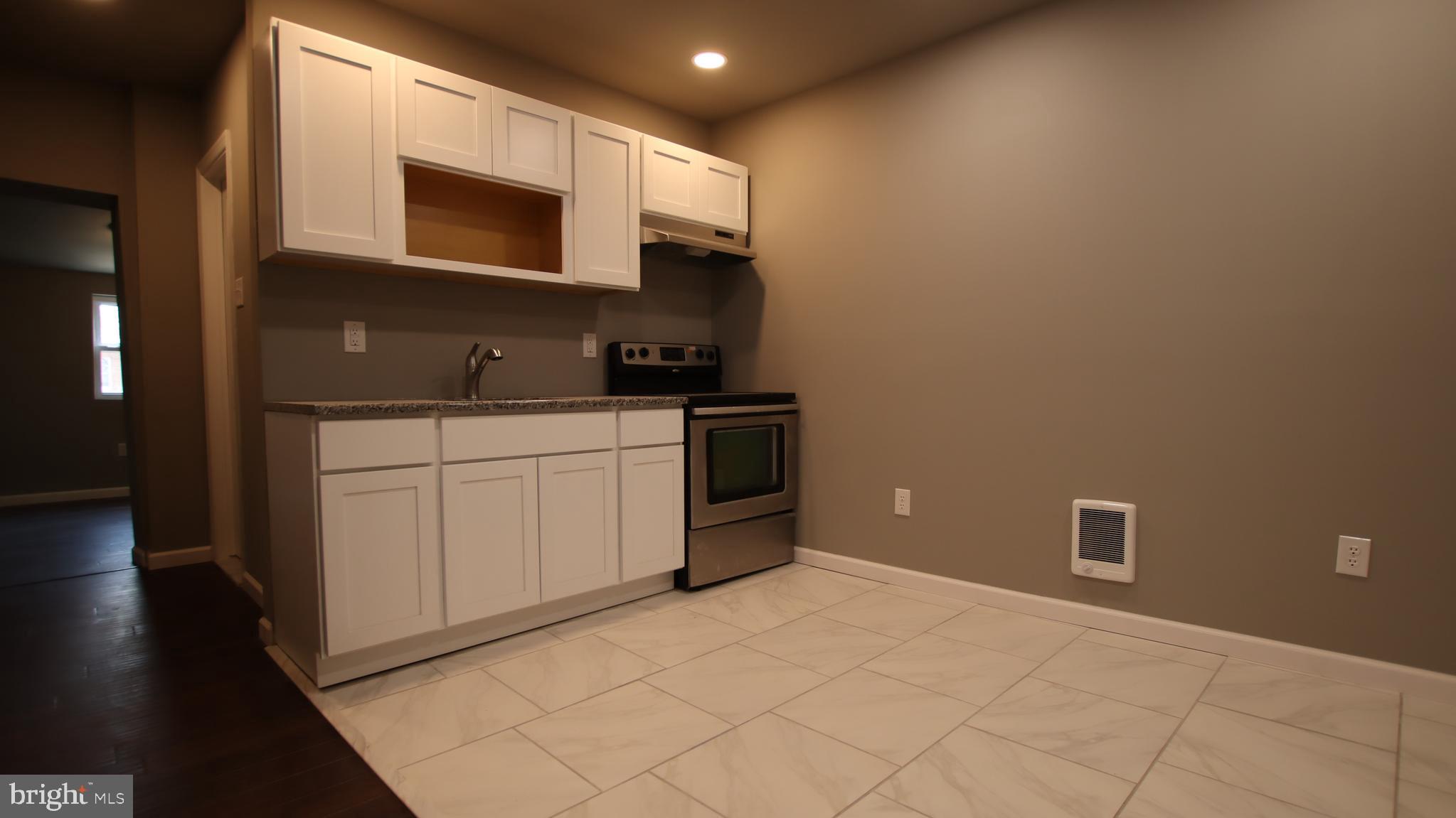 4932 West Thompson Street, Unit 2 Philadelphia, PA 19131 - Photo 2 of 24 a kitchen with stainless steel appliances a stove microwave and sink
