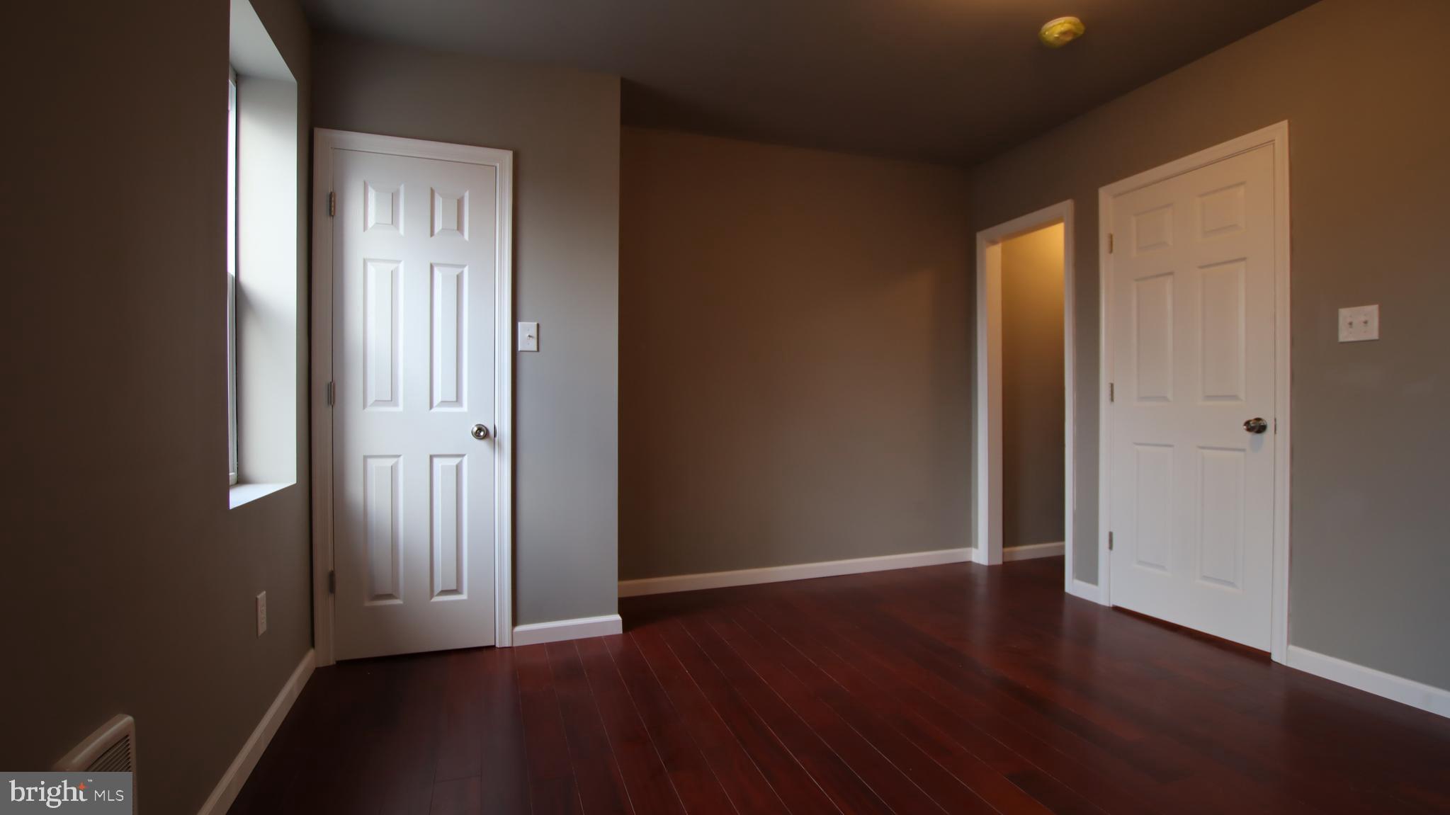 4932 West Thompson Street, Unit 2 Philadelphia, PA 19131 - Photo 21 of 24 an empty room with wooden floor and windows