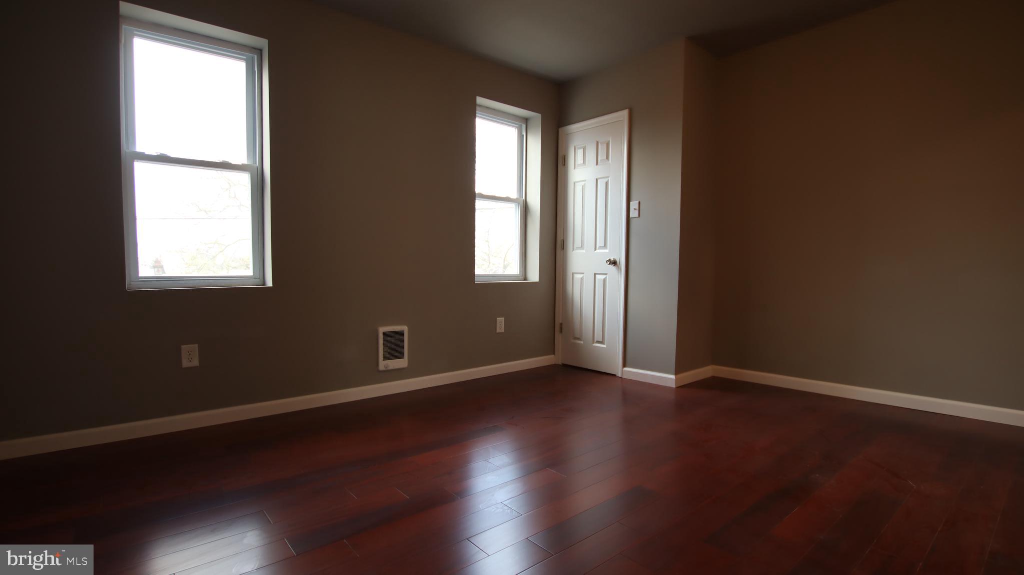 4932 West Thompson Street, Unit 2 Philadelphia, PA 19131 - Photo 22 of 24 an empty room with wooden floor and windows