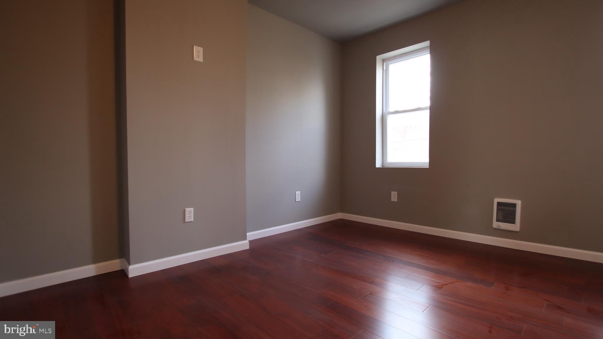4932 West Thompson Street, Unit 2 Philadelphia, PA 19131 - Photo 24 of 24 an empty room with wooden floor and windows