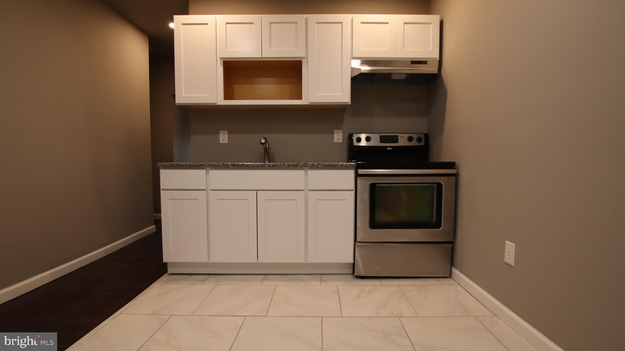 4932 West Thompson Street, Unit 2 Philadelphia, PA 19131 - Photo 3 of 24 a kitchen with a stove and a microwave