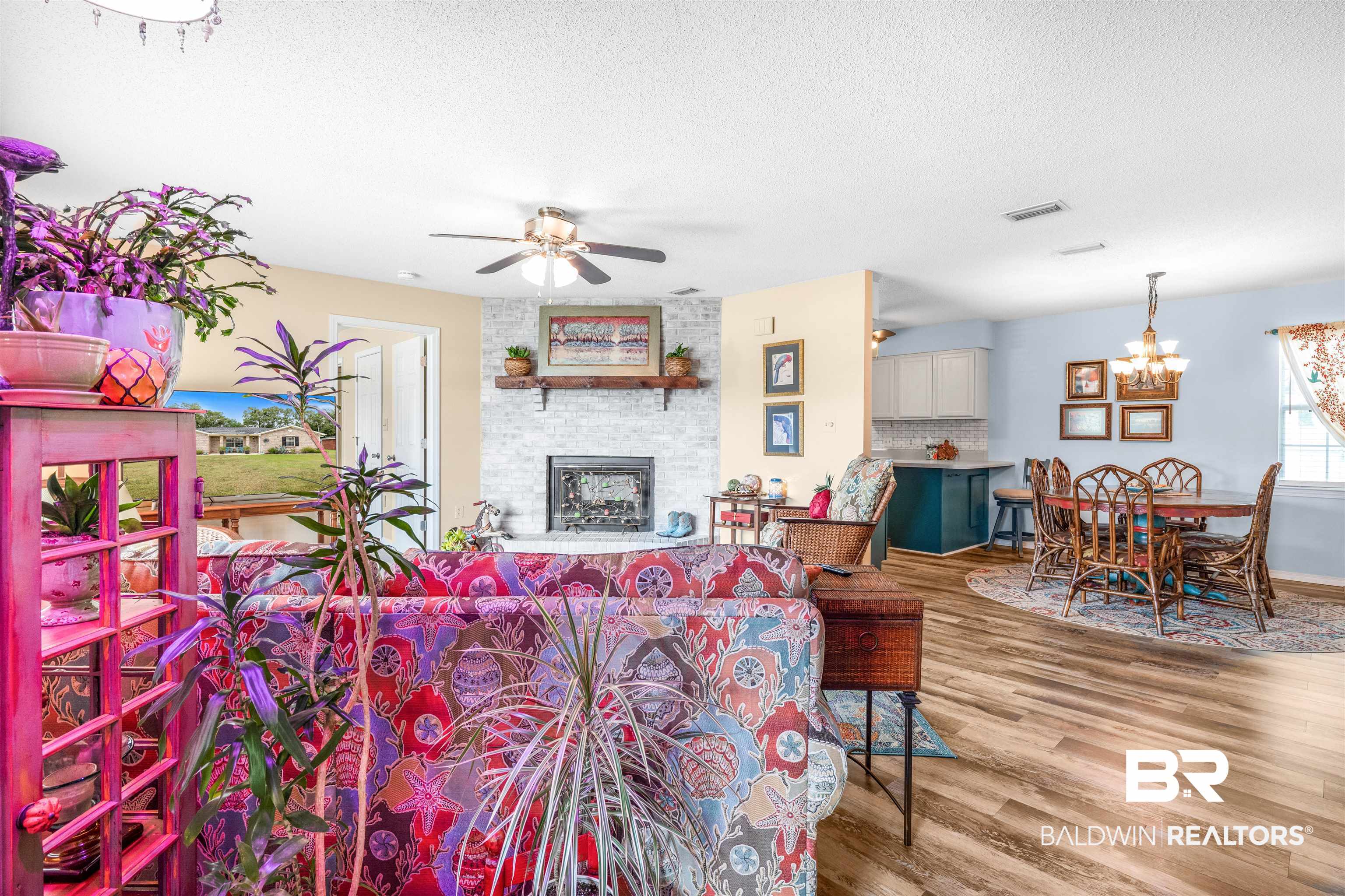 518 Ariel Avenue Foley, AL 36535 - Photo 5 of 47 Living room with ceiling fan with notable chandelier, wood-type flooring, a brick fireplace, and a textured ceiling