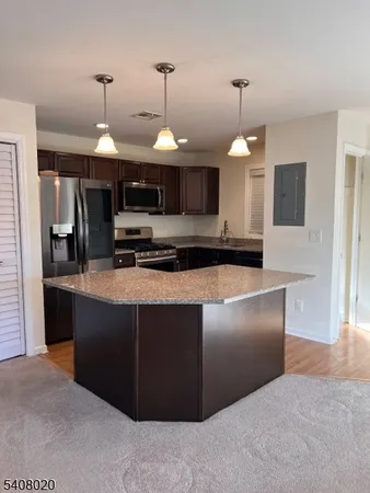 a large kitchen with stainless steel appliances granite countertop a stove and a refrigerator