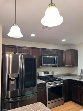 a kitchen with stainless steel appliances granite countertop a stove a refrigerator and a sink