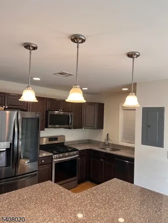 a kitchen with a stove and a wooden floor