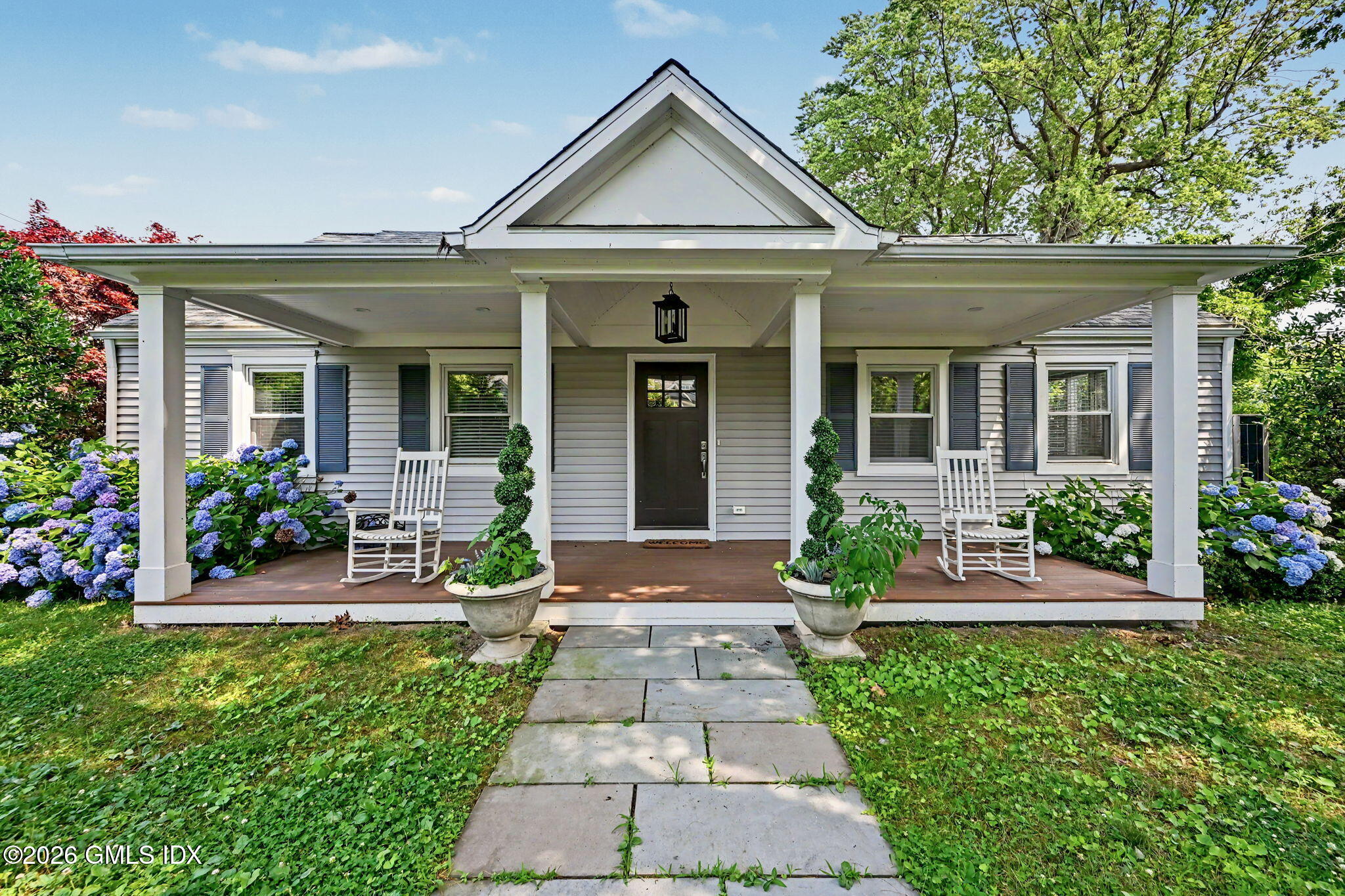 124 Shore Road Old Greenwich, CT 06870 - Photo 1 of 28 front view of a house with a yard and potted plants