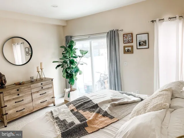 a bedroom with a bed and a potted plant