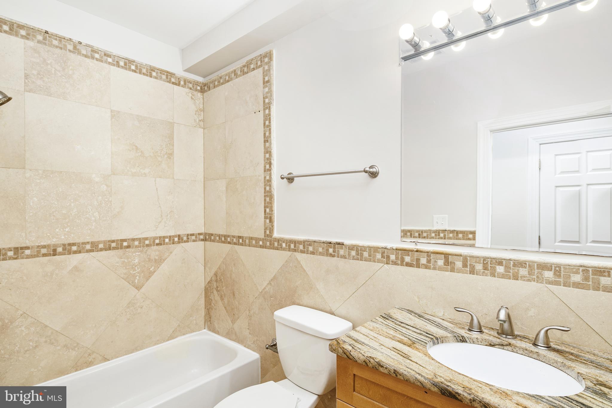 2339 Catharine Street, Unit 1 Philadelphia, PA 19146 - Photo 15 of 29 a bathroom with a granite countertop sink mirror vanity and toilet