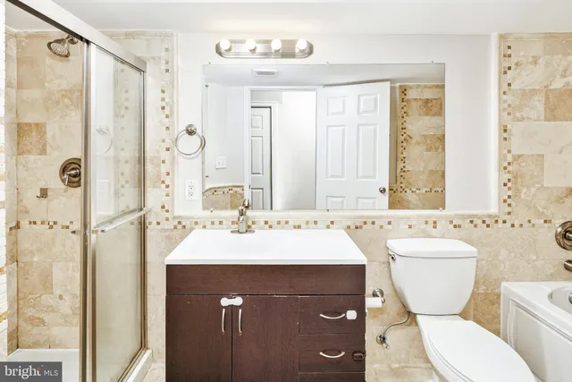 a bathroom with a sink toilet mirror and shower