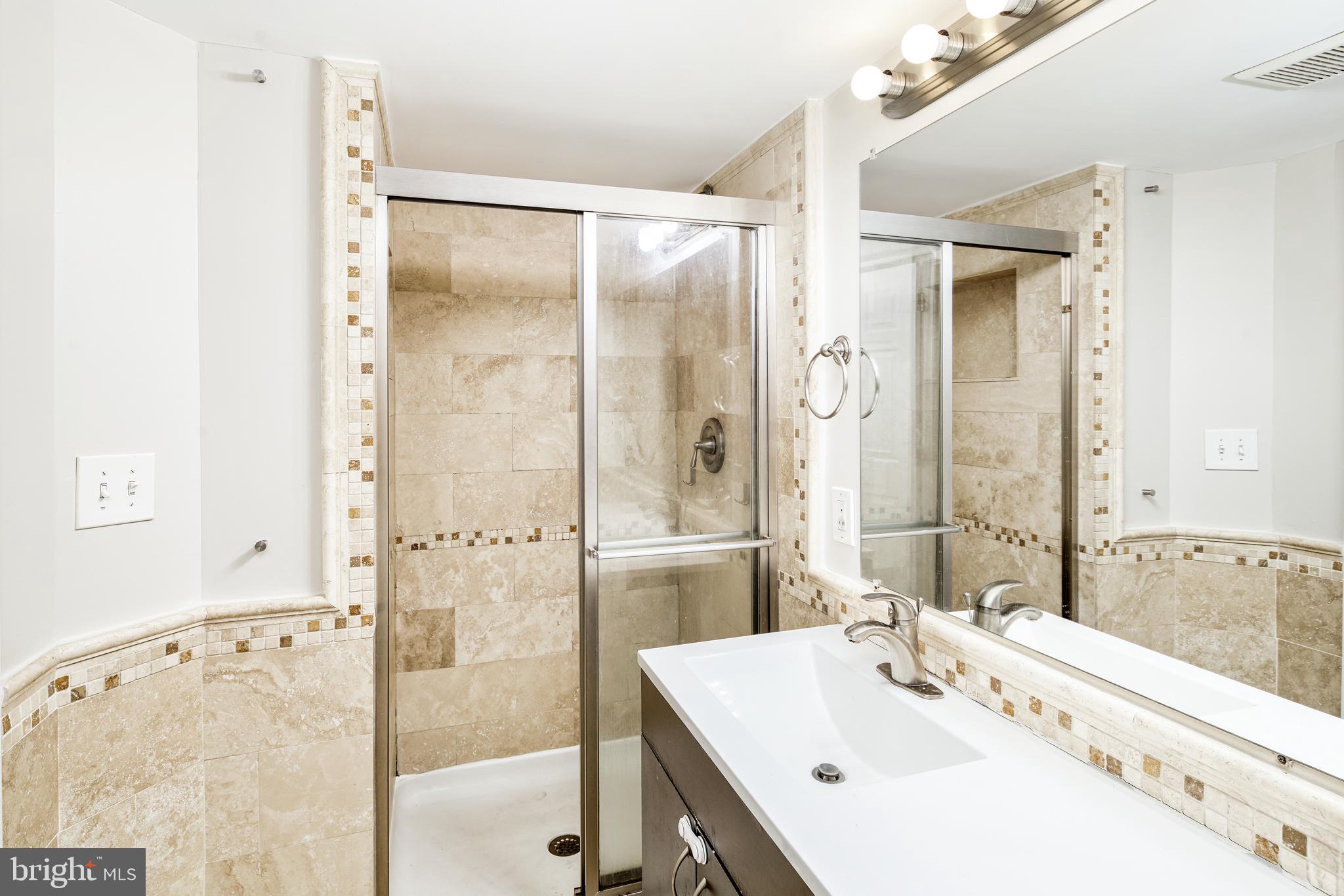 2339 Catharine Street, Unit 1 Philadelphia, PA 19146 - Photo 22 of 29 a bathroom with a bathtub shower sink and a mirror
