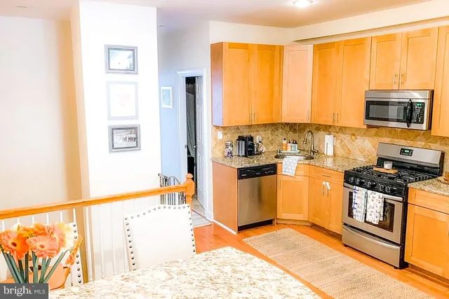 a kitchen with stainless steel appliances granite countertop a stove top oven and a refrigerator