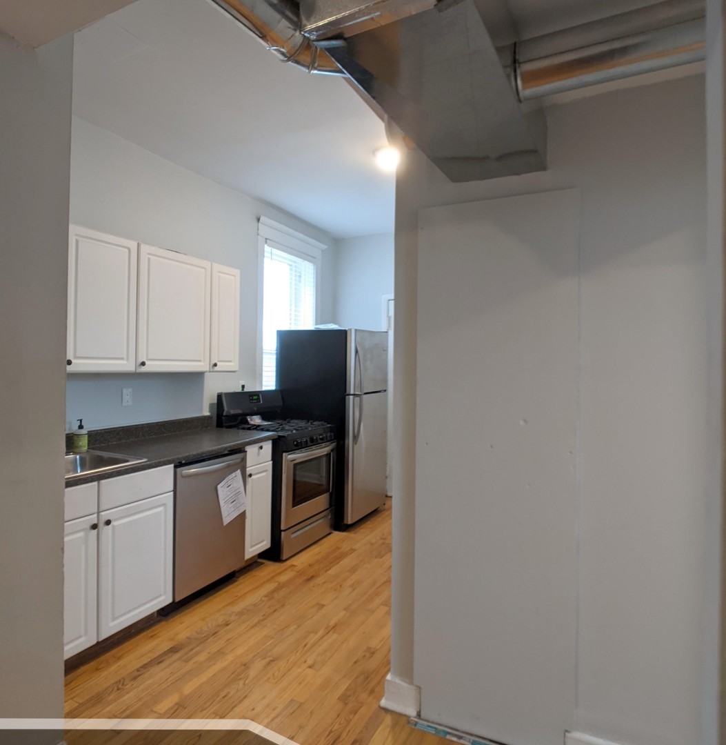 3544 North Halsted Street, Unit 2R Chicago, IL 60657 - Photo 4 of 13 a kitchen with stainless steel appliances a sink a stove a microwave a refrigerator a cabinets and wooden floor
