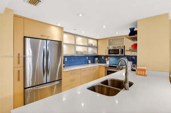 a kitchen with kitchen island a sink appliances and a counter top space