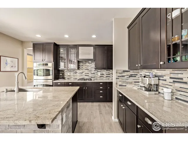 a kitchen with kitchen island granite countertop a sink counter top space appliances and cabinets