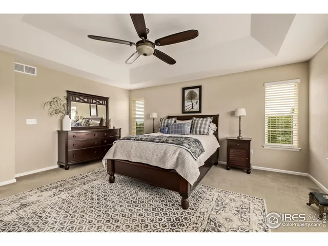 a bedroom with a bed a dresser and a chandelier