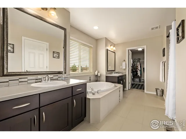 a bathroom with a sink vanity granite tub shower and a mirror