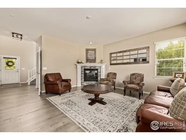 a living room with furniture large window and a fireplace