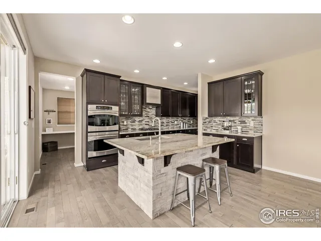 a kitchen with stainless steel appliances kitchen island granite countertop a stove a sink a refrigerator and a refrigerator