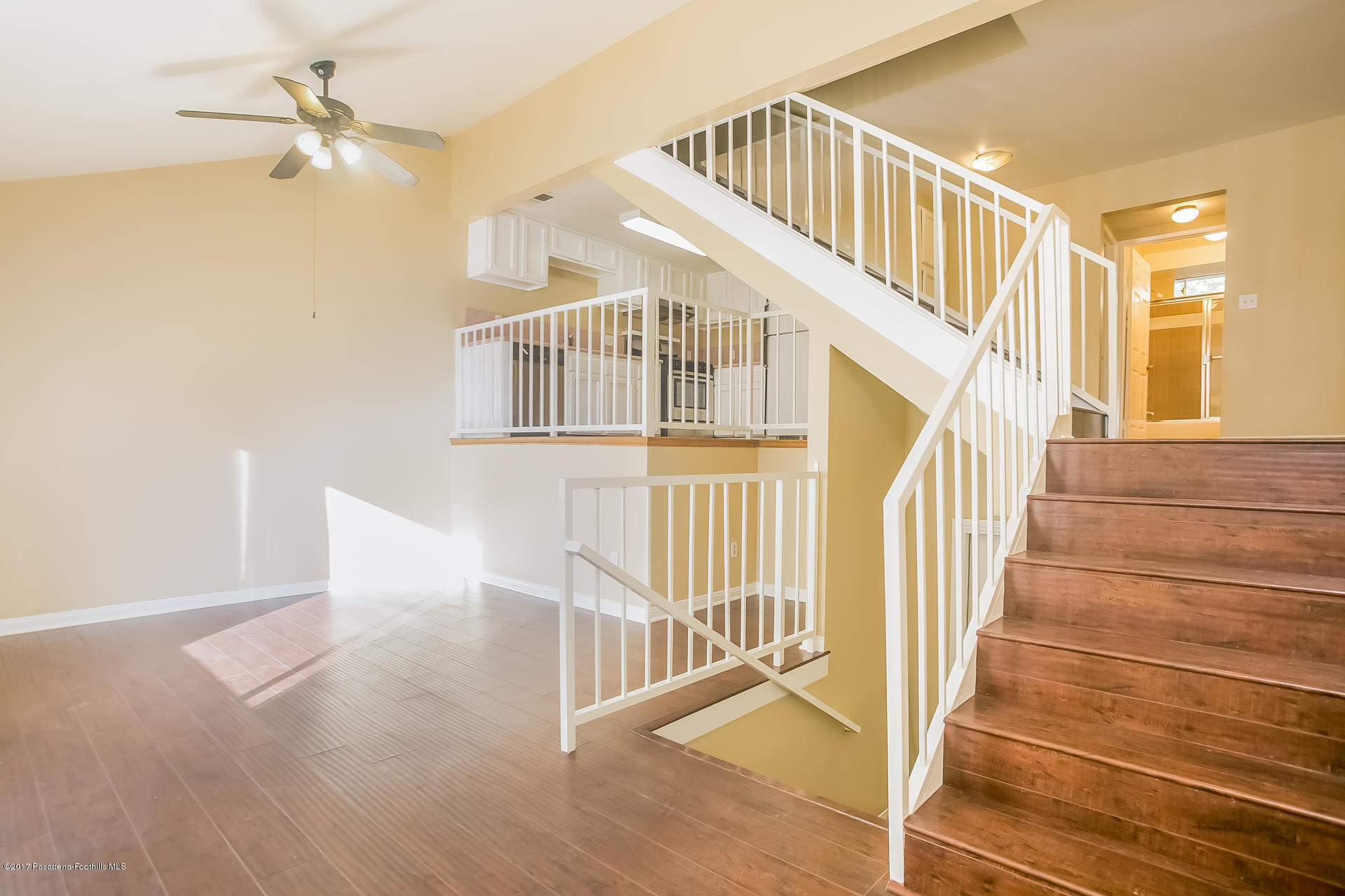 a view of staircase with white walls and a chandelier