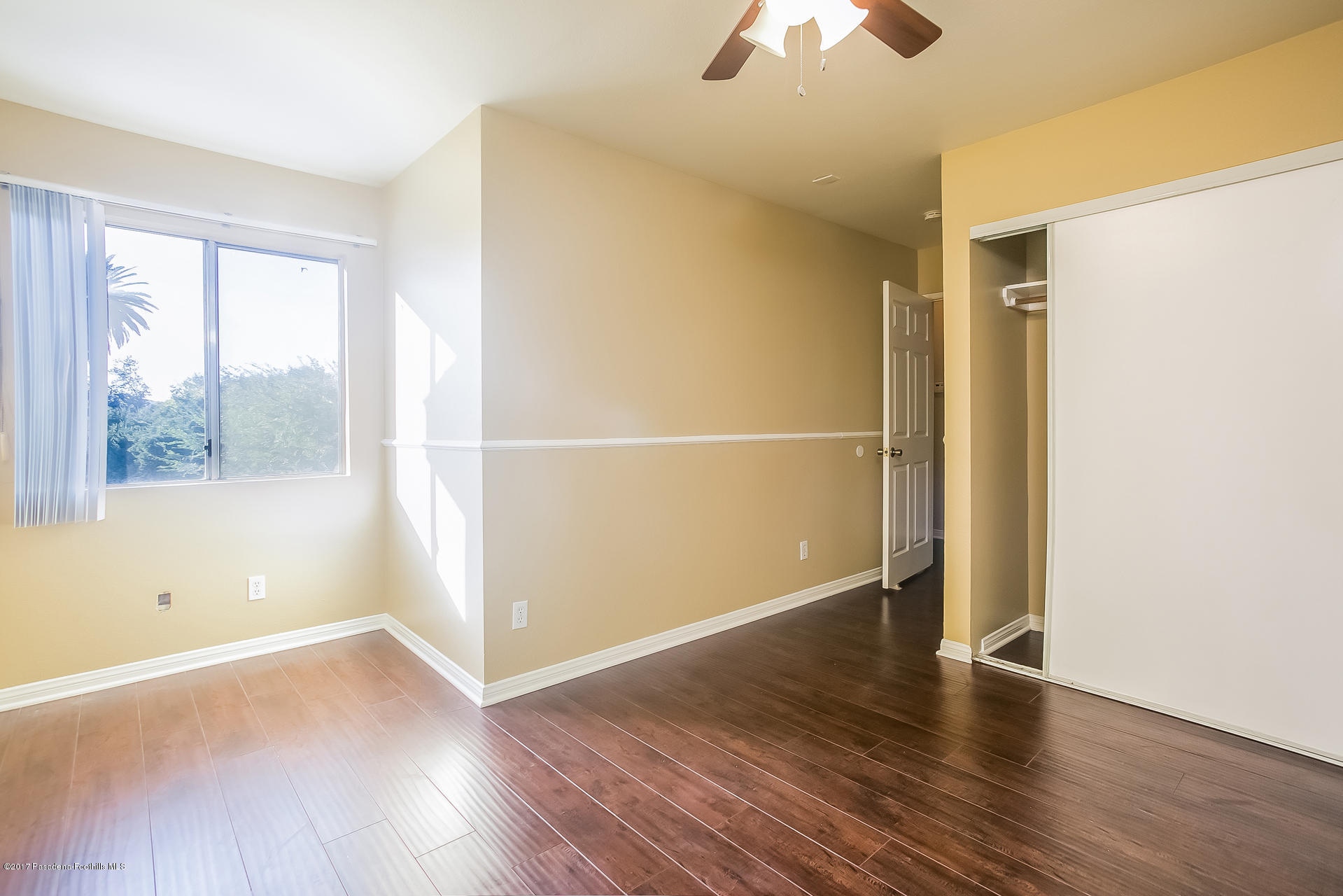 248 East Washington Boulevard, Unit 4 Pasadena, CA 91104 - Photo 14 of 19 an empty room with wooden floor chandelier fan and windows