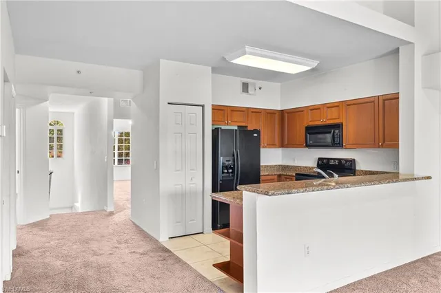a view of a kitchen with a sink and a refrigerator