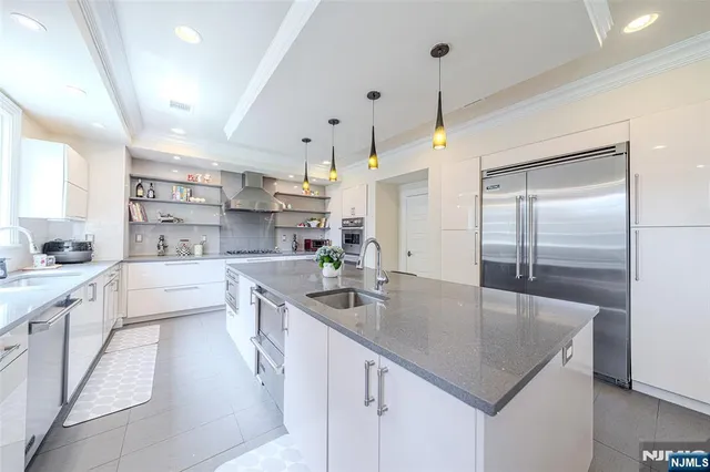 a kitchen with kitchen island a sink a center island and stainless steel appliances