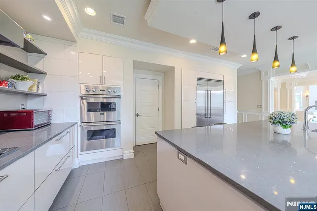 a kitchen with stainless steel appliances a kitchen island a stove a refrigerator and a sink