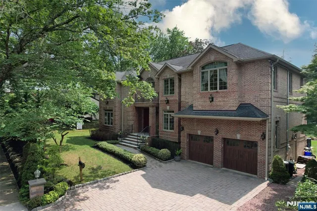 a front view of a house with a garden and plants