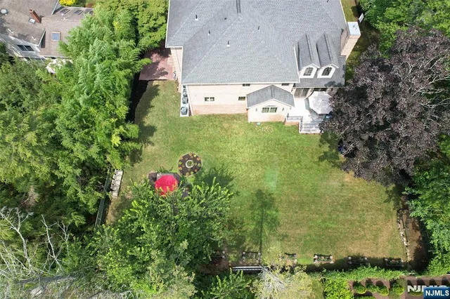 an aerial view of residential house with outdoor space and trees all around