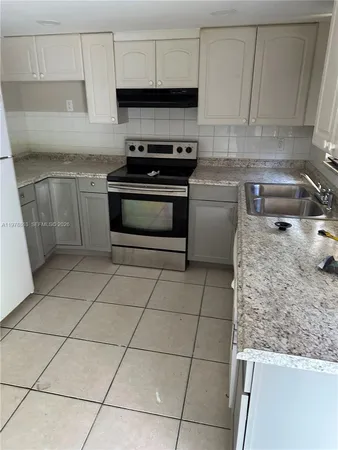 a kitchen with a stove a sink and a counter top space