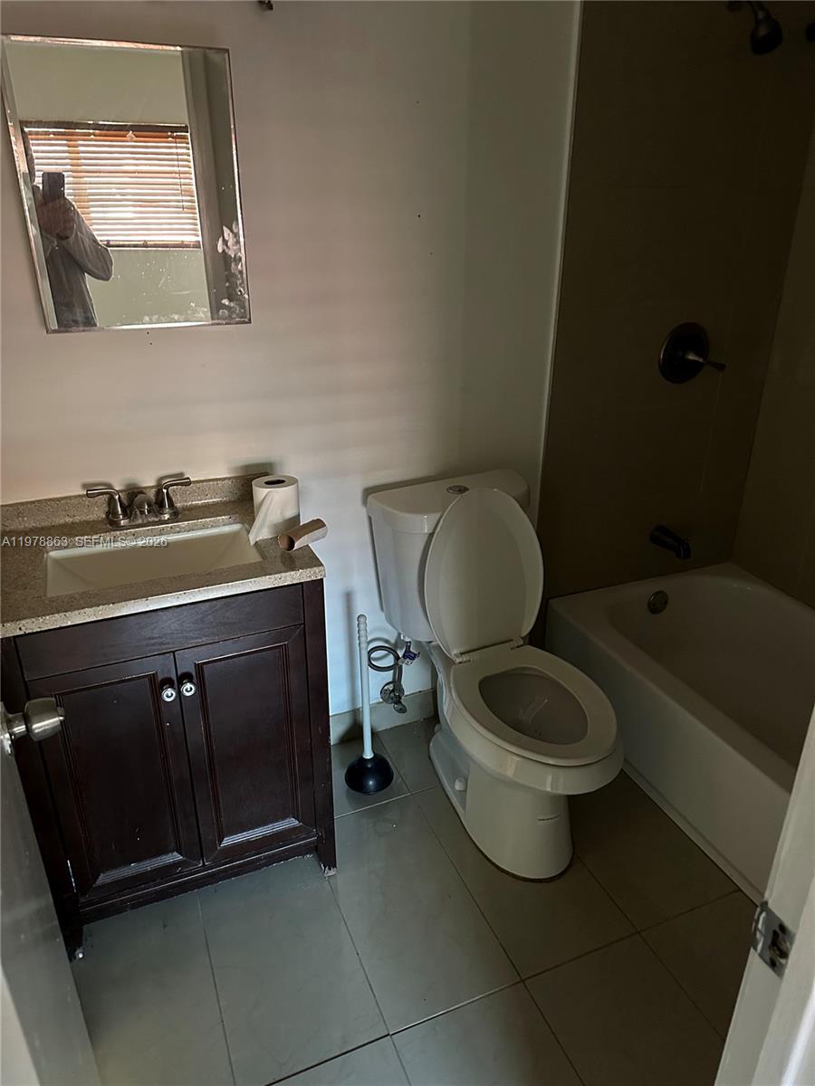 5223 Northwest 27th Street, Unit 9B Lauderhill, FL 33313 - Photo 4 of 4 a bathroom with a toilet sink and mirror
