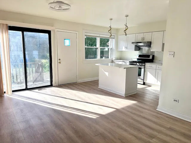 a living room with stainless steel appliances kitchen island granite countertop a stove a sink and a refrigerator