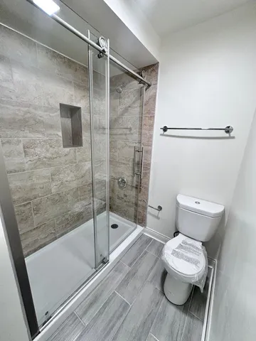a bathroom with a toilet and a shower