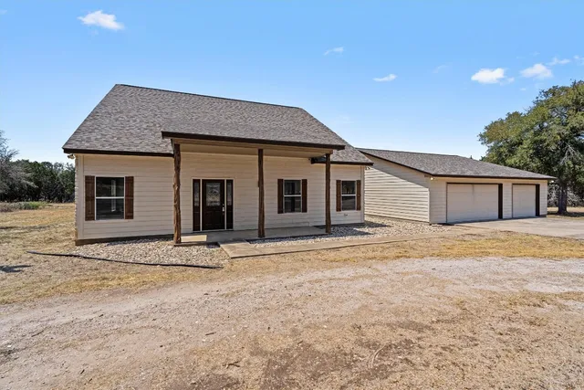 a view of an empty room with wooden floor and stairs