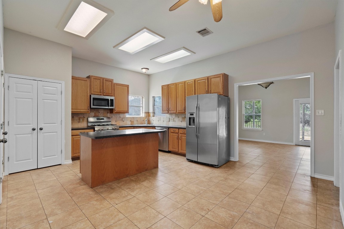 25600 Ronald Reagan Boulevard Georgetown, TX 78633 - Photo 18 of 36 a kitchen with stainless steel appliances granite countertop a refrigerator a stove a sink and a microwave