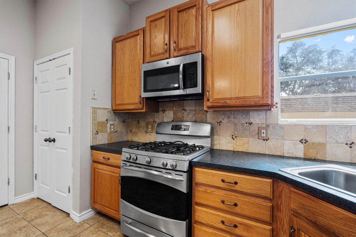 25600 Ronald Reagan Boulevard Georgetown, TX 78633 - Photo 20 of 36 a kitchen with stainless steel appliances granite countertop a sink stove and microwave
