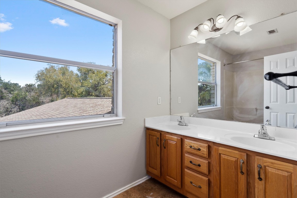 25600 Ronald Reagan Boulevard Georgetown, TX 78633 - Photo 29 of 36 a bathroom with a double vanity sink and a mirror