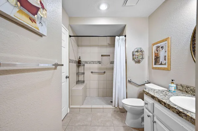 a bathroom with a granite countertop sink toilet and shower