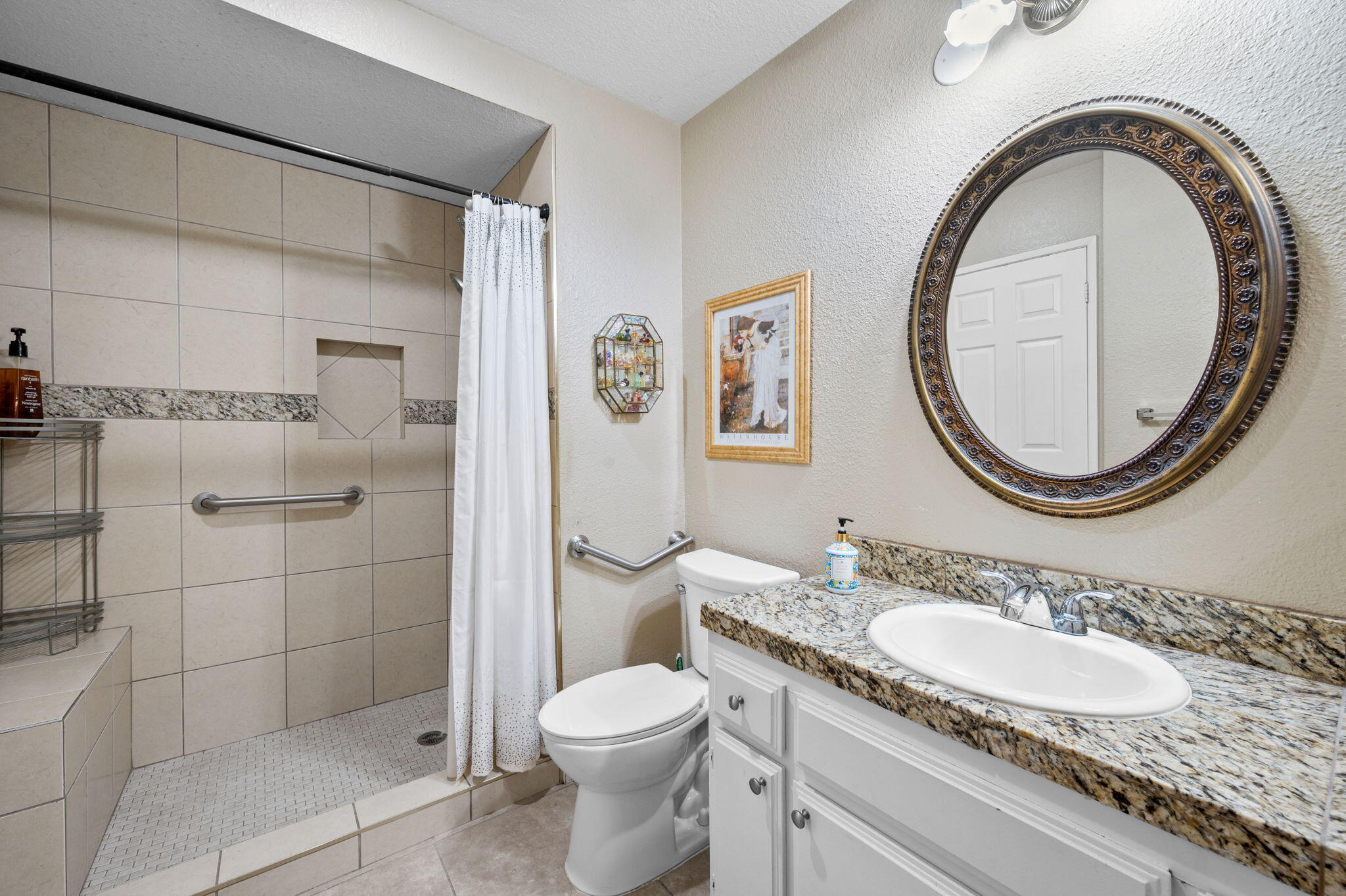 49275 Douglas Street Indio, CA 92201 - Photo 13 of 37 a bathroom with a granite countertop toilet a sink and a mirror