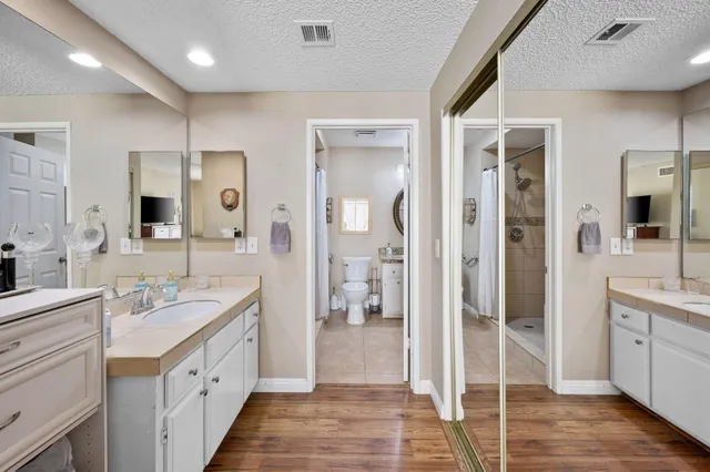 a spacious bathroom with a double vanity sink a mirror and a shower