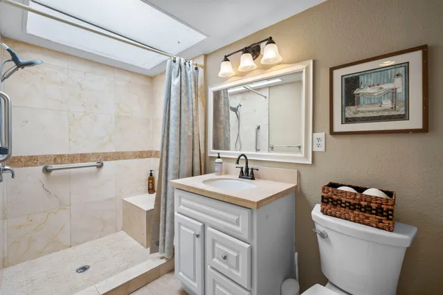 a bathroom with a sink a toilet and shower