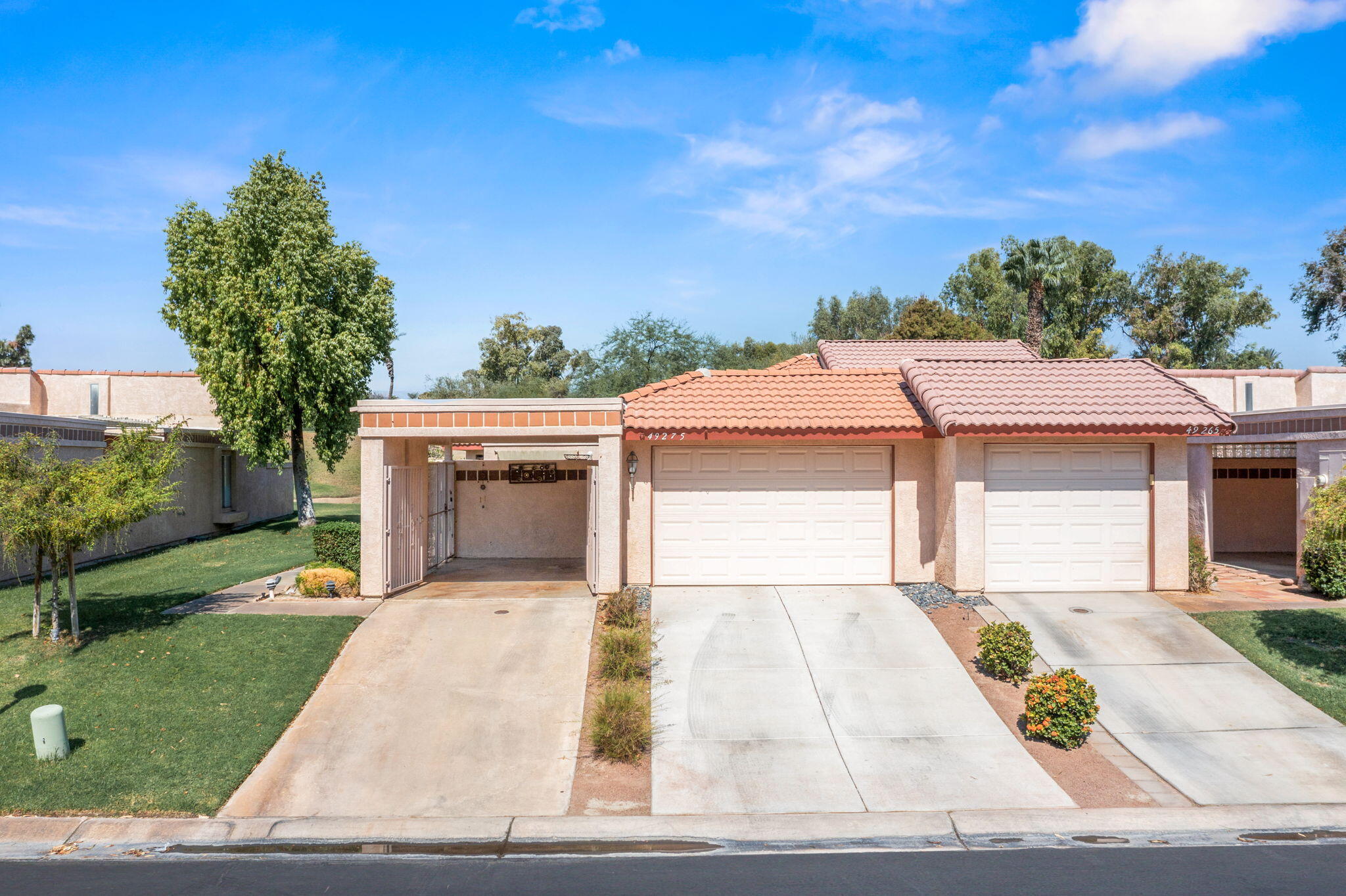 49275 Douglas Street Indio, CA 92201 - Photo 23 of 37 a front view of a house with a yard and garage