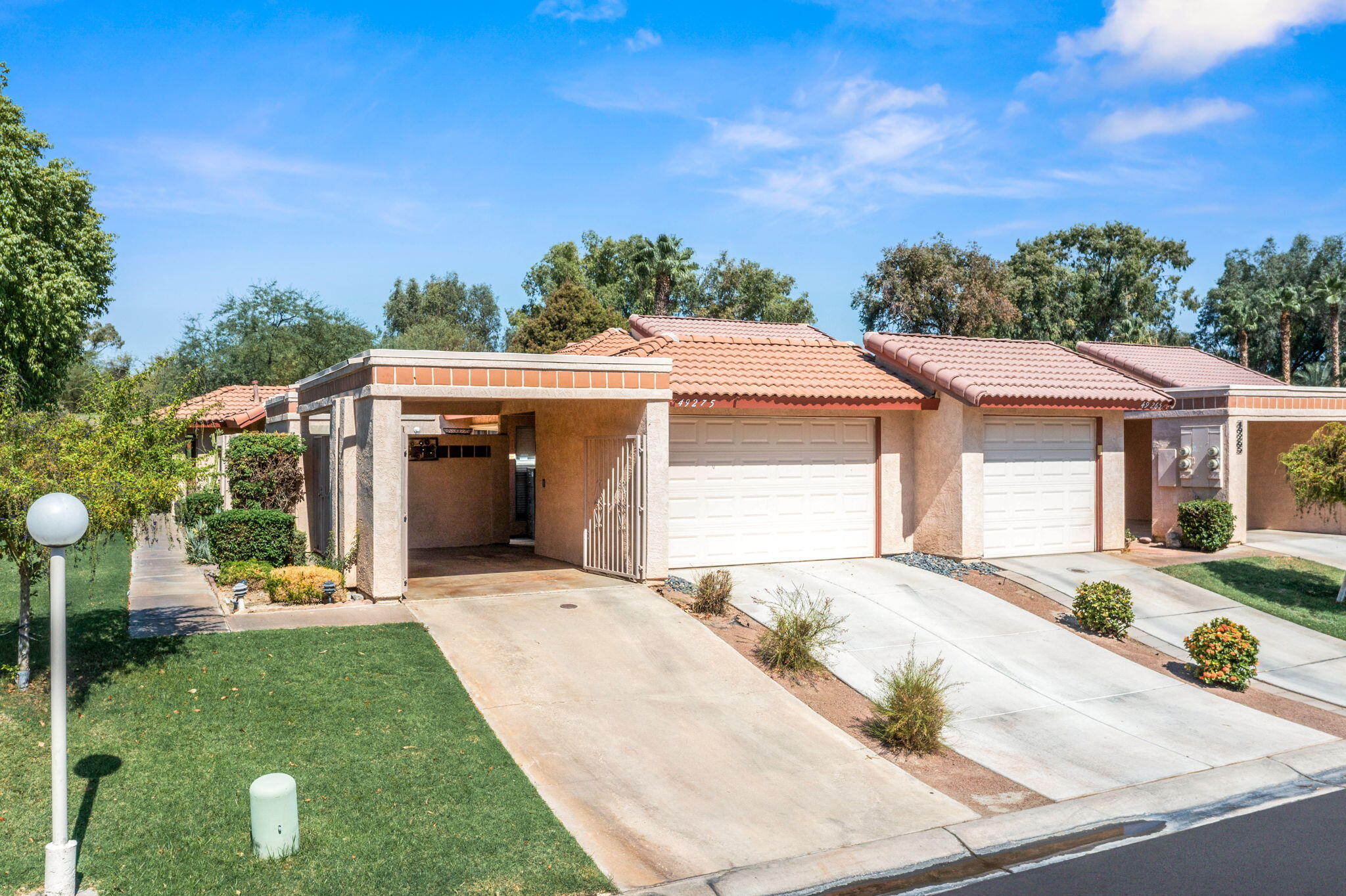 49275 Douglas Street Indio, CA 92201 - Photo 28 of 37 a front view of a house with a yard and garage