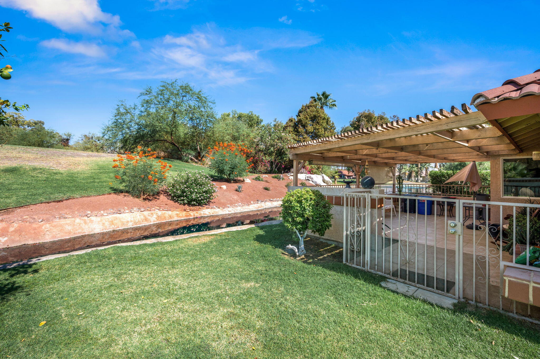 49275 Douglas Street Indio, CA 92201 - Photo 32 of 37 a view of a house with a big yard and potted plants