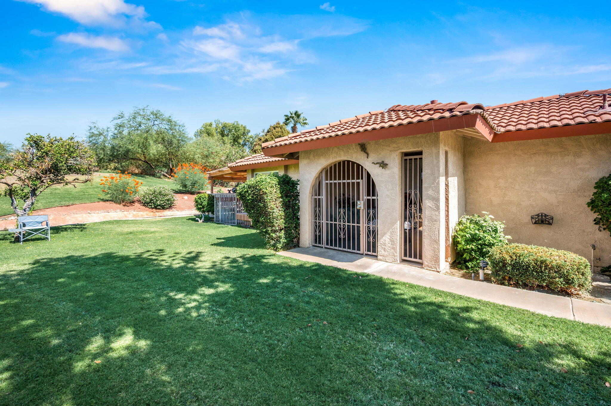 49275 Douglas Street Indio, CA 92201 - Photo 36 of 37 a view of a white house with a big yard and potted plants