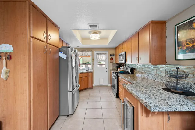 a kitchen with stainless steel appliances granite countertop a sink refrigerator and cabinets