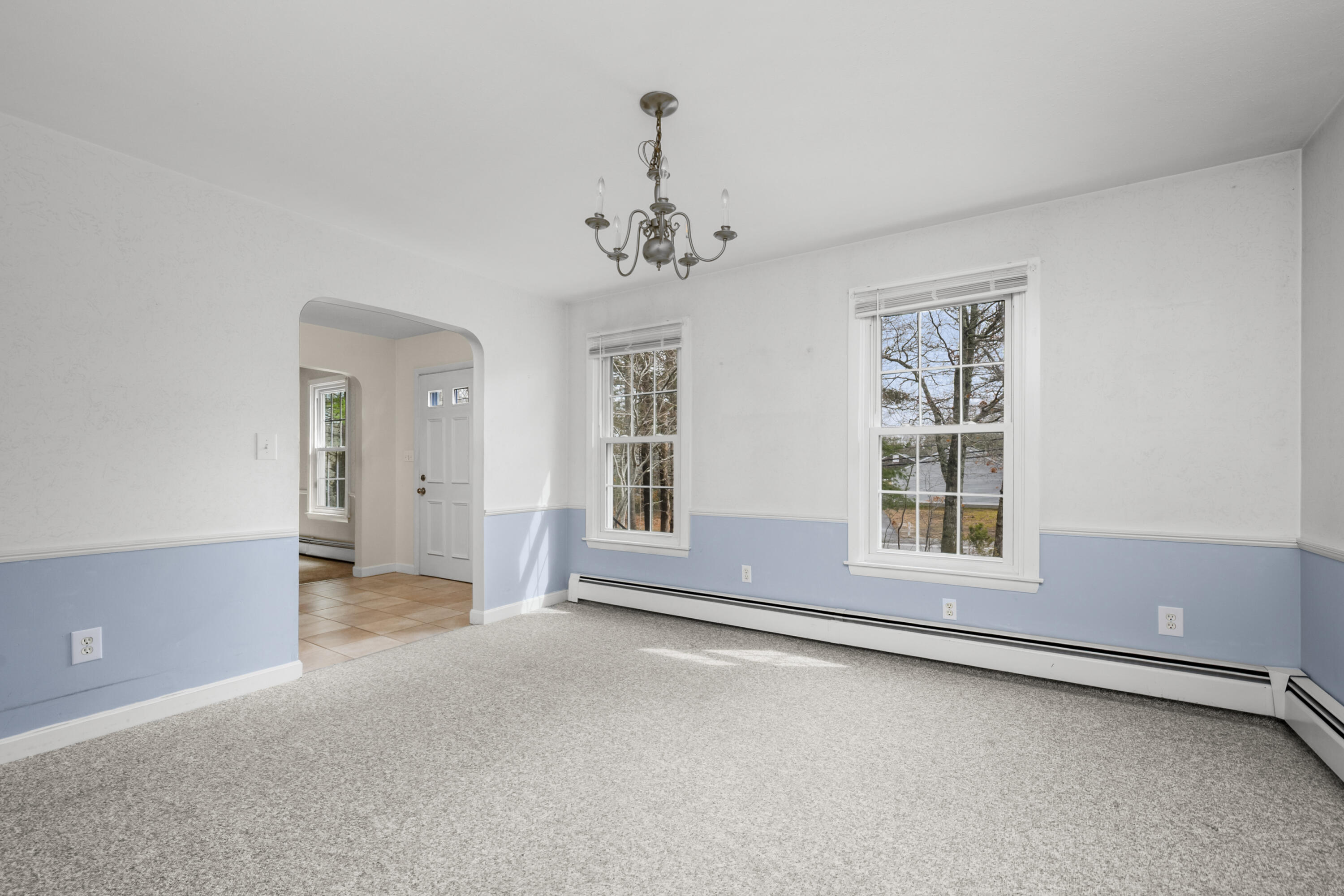 33 Head Of The Bay Road Buzzards Bay, MA 02532 - Photo 9 of 46 an empty room with chandelier and windows