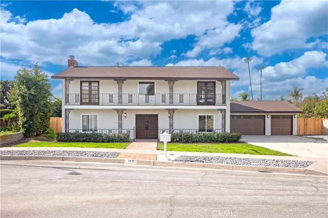 a front view of a house with a garden and plants