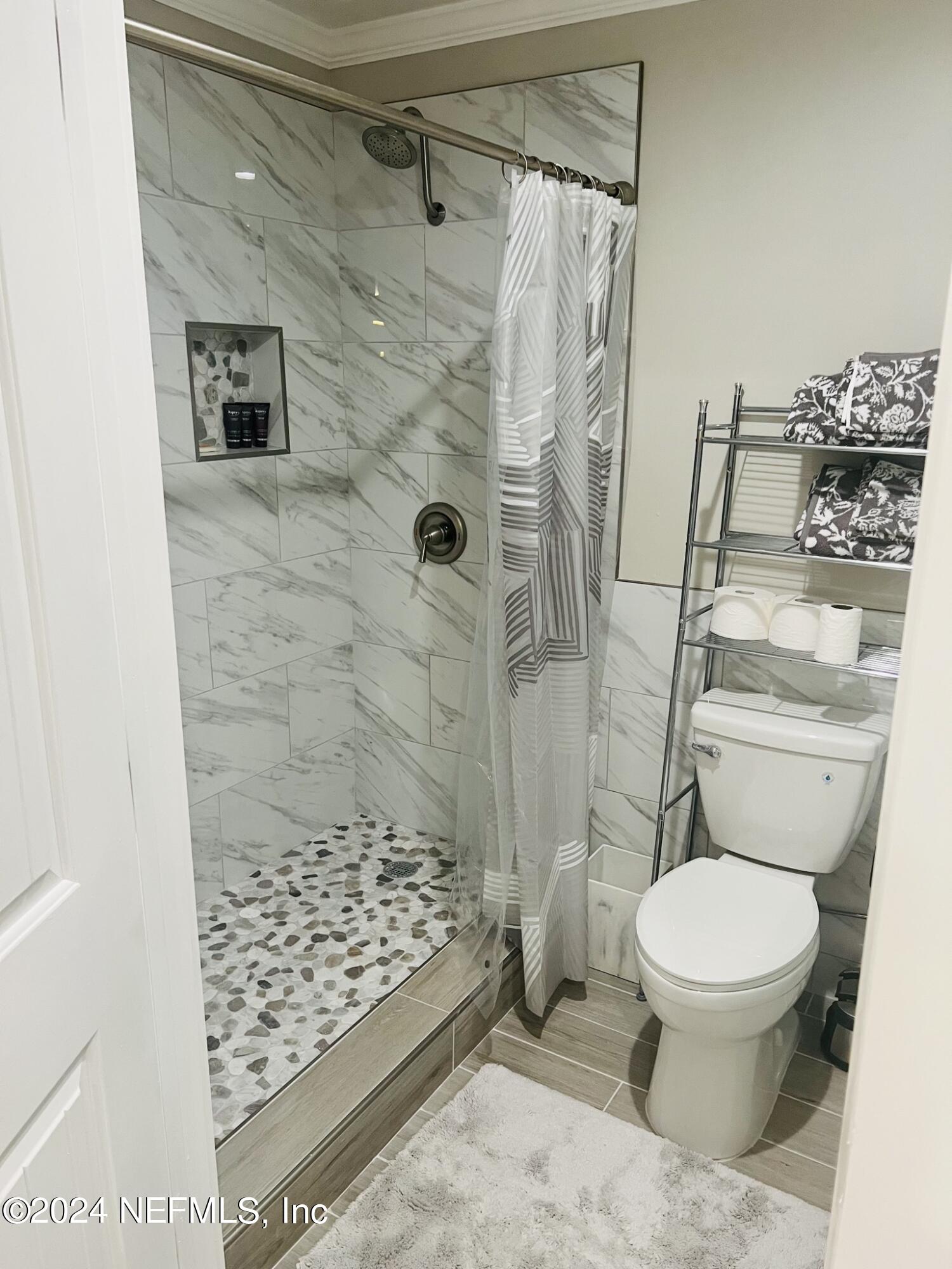 955 Registry Boulevard, Unit 210 St. Augustine, FL 32092 - Photo 22 of 31 a bathroom with a toilet and a shower