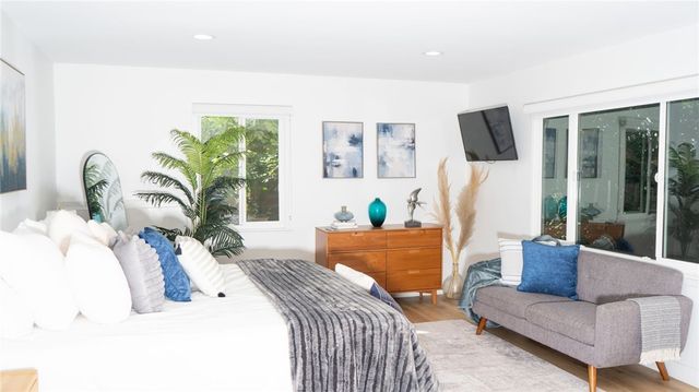 a bedroom with furniture and a large window